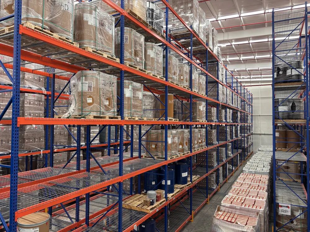 Rack selectivo con vigas naranjas y tarimas cargadas