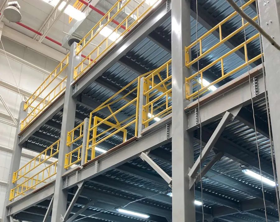 Mezzanine industrial con barandal amarillo sobre área de almacenamiento